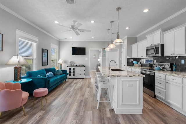 1790 Catfish Ln, Crystal Beach, TX 77650 - kitchen featuring appliances with stainless steel finishes, open floor plan, white cabinets, a ceiling fan, and backsplash
