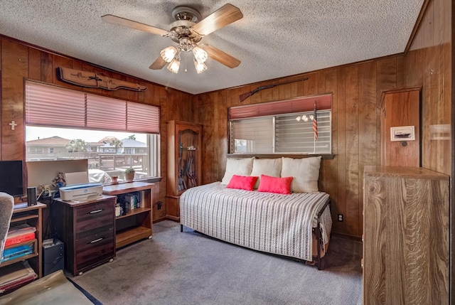 1120 Redfish St, Bayou Vista, TX 77563 - carpeted bedroom featuring wood walls, a textured ceiling, a ceiling fan, and an office area