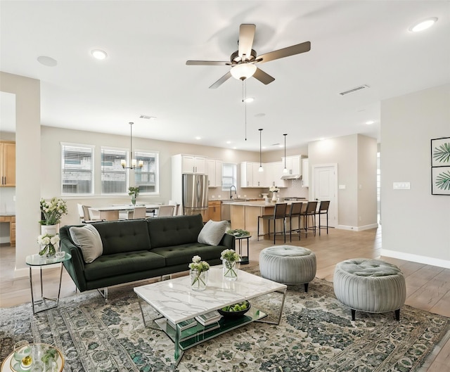 18314 Pedernales Springs Dr, Cypress, TX 77433 - living room featuring plenty of natural light, recessed lighting, light wood-style flooring, a ceiling fan, and a chandelier