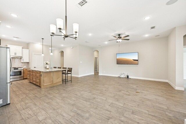 18314 Pedernales Springs Dr, Cypress, TX 77433 - kitchen featuring arched walkways, appliances with stainless steel finishes, open floor plan, ceiling fan, and recessed lighting