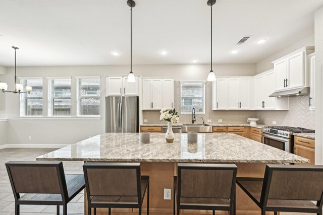 18314 Pedernales Springs Dr, Cypress, TX 77433 - kitchen featuring stainless steel appliances, backsplash, healthy amount of natural light, a kitchen breakfast bar, and recessed lighting