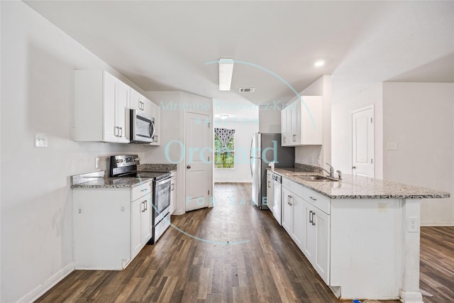 15689 Del Norte Dr, Conroe, TX 77306 - kitchen with appliances with stainless steel finishes, dark wood-style flooring, light stone counters, and white cabinets