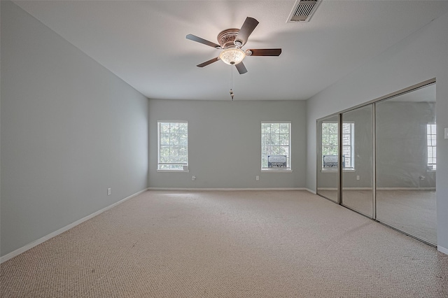 4001 Tanglewilde St Unit 1402, Houston, TX 77063 - unfurnished bedroom featuring multiple windows, carpet floors, a ceiling fan, and a closet
