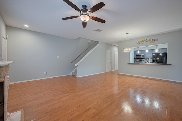 4001 Tanglewilde St Unit 1402, Houston, TX 77063 - unfurnished living room featuring a ceiling fan, stairway, light wood-type flooring, and recessed lighting
