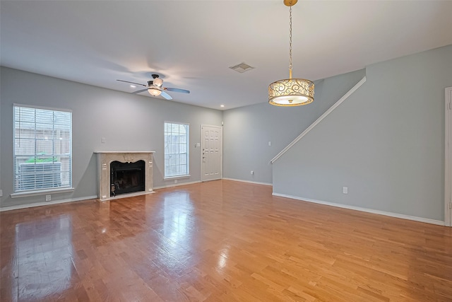 4001 Tanglewilde St Unit 1402, Houston, TX 77063 - unfurnished living room with a ceiling fan, a high end fireplace, and light wood-style floors