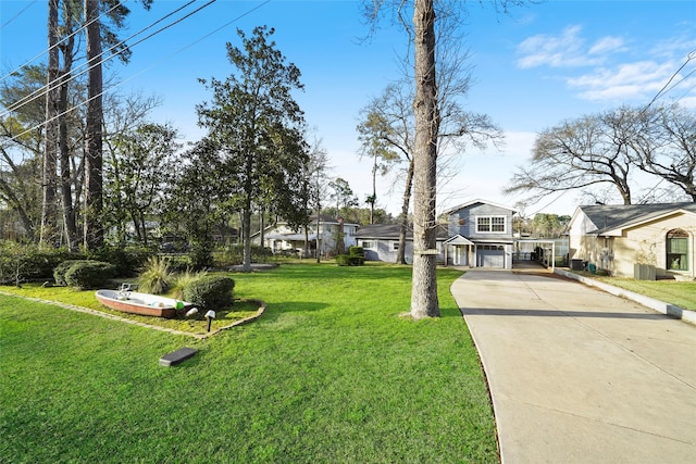 13318 Southshore Dr, Conroe, TX 77304 - view of grassy yard with driveway, a carport, and a residential view