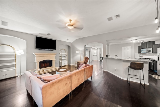 5726 Straight Way, Houston, TX 77339 - living room with ceiling fan, arched walkways, dark wood-style flooring, and a fireplace with raised hearth