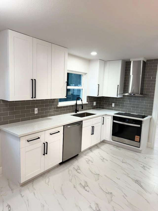 25907 Maplewood Dr, Spring, TX 77386 - kitchen with stainless steel dishwasher, wall oven, wall chimney range hood, light marble finish flooring, and recessed lighting