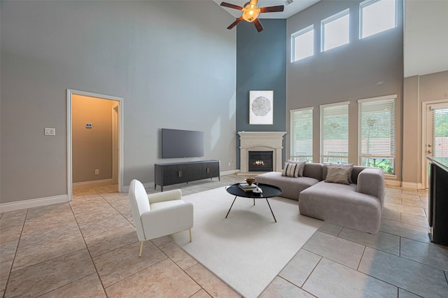 10022 Foggy Riv, Missouri City, TX 77459 - living room featuring a towering ceiling, a glass covered fireplace, ceiling fan, healthy amount of natural light, and tile patterned flooring