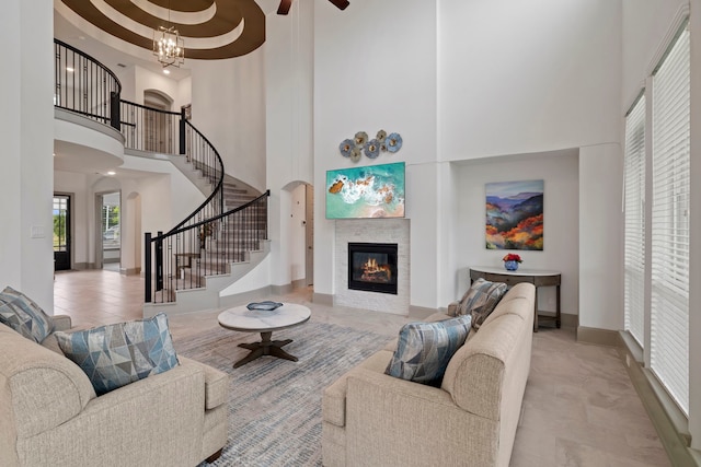 17907 Aqua Haven Ln, Conroe, TX 77302 - tiled living room with a towering ceiling, stairs, a fireplace, arched walkways, and a ceiling fan