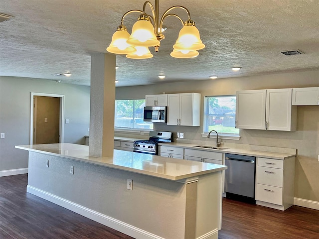415 Sevenhampton Ln, Houston, TX 77015 - kitchen with stainless steel appliances, a textured ceiling, dark wood-type flooring, white cabinetry, and healthy amount of natural light