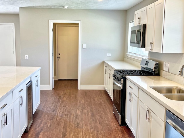 415 Sevenhampton Ln, Houston, TX 77015 - kitchen featuring stainless steel appliances, dark wood-style flooring, white cabinets, wine cooler, and light stone countertops