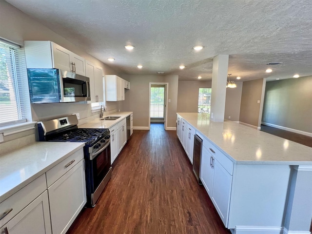 415 Sevenhampton Ln, Houston, TX 77015 - kitchen with appliances with stainless steel finishes, dark wood-type flooring, white cabinetry, light stone counters, and a textured ceiling