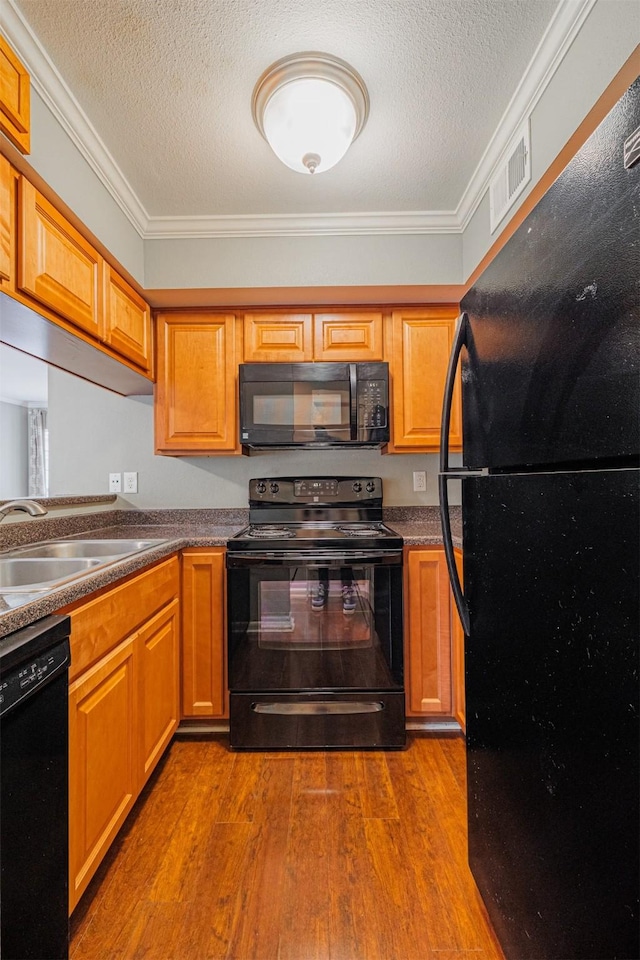 2621 Marilee Ln Unit 3, Houston, TX 77057 - kitchen with black appliances, wood finished floors, a textured ceiling, ornamental molding, and dark countertops