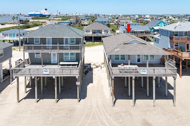 1310 Seashell Dr, Surfside Beach, TX 77541 - back of house featuring a balcony, dirt driveway, and a residential view
