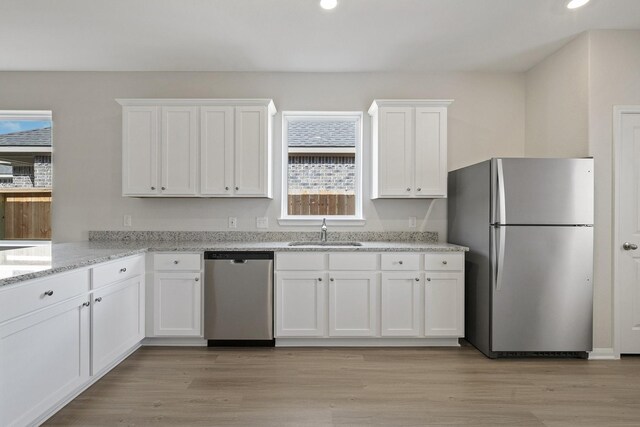 1031 Rosewood Trl, Beasley, TX 77417 - kitchen featuring stainless steel appliances, white cabinetry, recessed lighting, light stone countertops, and light wood-style floors