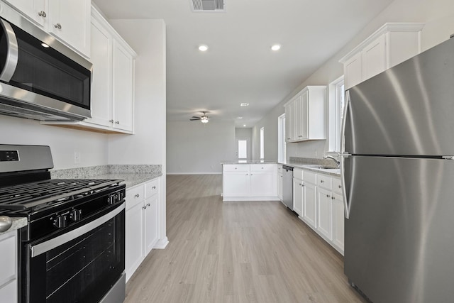 1031 Rosewood Trl, Beasley, TX 77417 - kitchen with appliances with stainless steel finishes, light wood-type flooring, white cabinetry, a ceiling fan, and recessed lighting