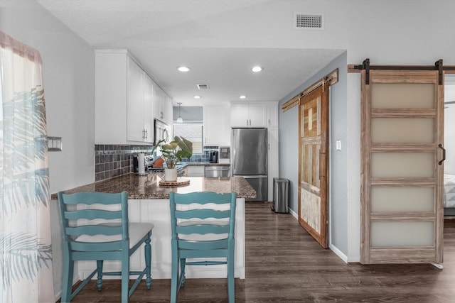 253 Barracuda St, Bayou Vista, TX 77563 - kitchen with stainless steel appliances, a barn door, a peninsula, tasteful backsplash, and recessed lighting