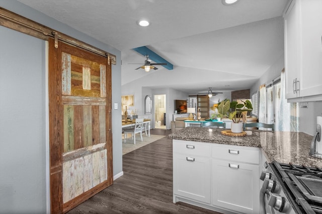 253 Barracuda St, Bayou Vista, TX 77563 - kitchen with a peninsula, ceiling fan, white cabinets, dark stone counters, and dark wood-type flooring