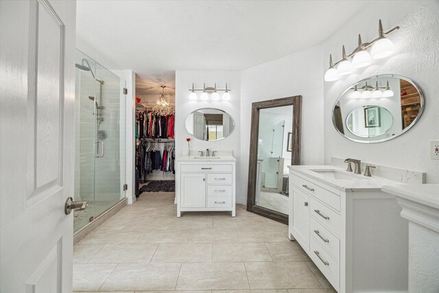 16063 Hidden Acres Dr, Houston, TX 77084 - full bath with a shower stall, two vanities, a chandelier, a walk in closet, and tile patterned floors