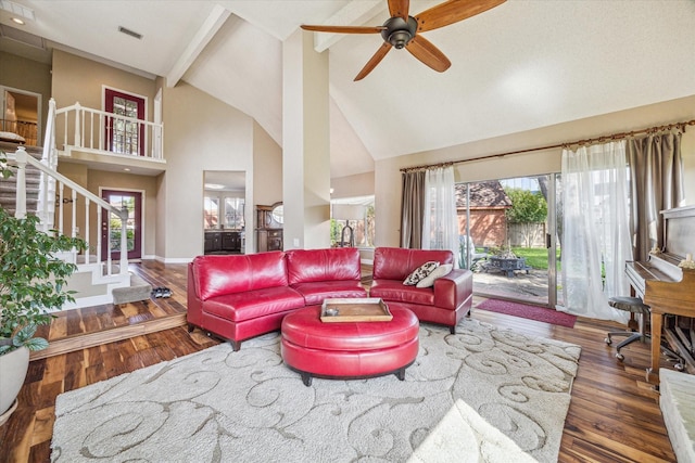 16063 Hidden Acres Dr, Houston, TX 77084 - living room featuring high vaulted ceiling, wood finished floors, beamed ceiling, ceiling fan, and stairs