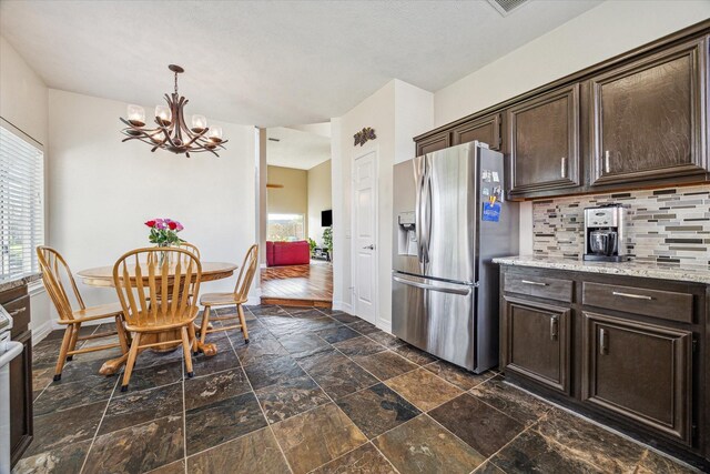 16063 Hidden Acres Dr, Houston, TX 77084 - kitchen featuring stainless steel appliances, healthy amount of natural light, dark brown cabinetry, and a chandelier