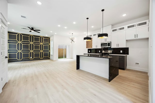 4601 Newberry St A/B, Unit A/B Houston, TX 77051 - kitchen with appliances with stainless steel finishes, open floor plan, light wood finished floors, a ceiling fan, and white cabinetry