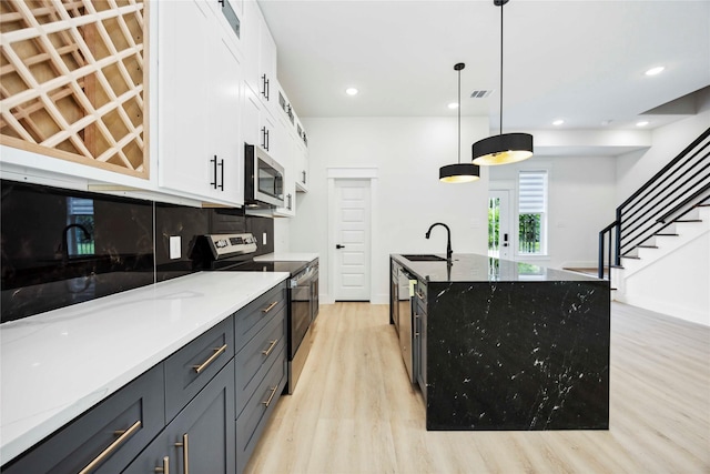 4601 Newberry St A/B, Unit A/B Houston, TX 77051 - kitchen featuring stainless steel appliances, light wood-style floors, white cabinetry, light stone countertops, and recessed lighting