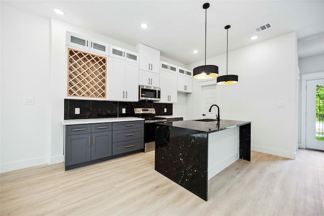4601 Newberry St A/B, Unit A/B Houston, TX 77051 - kitchen featuring stainless steel appliances, light wood finished floors, white cabinetry, tasteful backsplash, and dark stone countertops