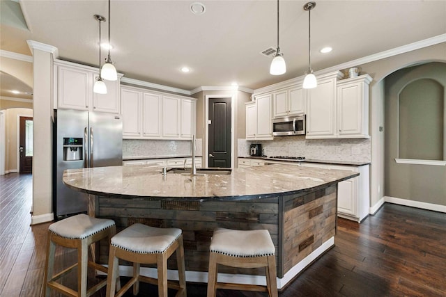 17522 Mineral Bluff Ln, Humble, TX 77346 - kitchen with arched walkways, stainless steel appliances, ornamental molding, dark wood-style flooring, and tasteful backsplash