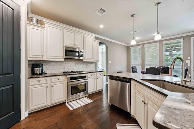17522 Mineral Bluff Ln, Humble, TX 77346 - kitchen featuring stainless steel appliances, crown molding, arched walkways, tasteful backsplash, and dark wood-style floors