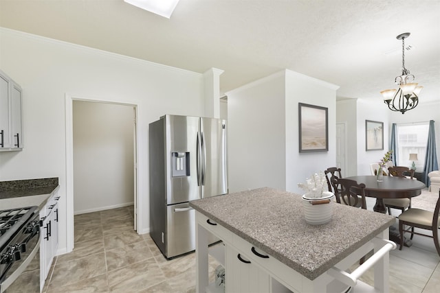7242 Foxcrest Ln, Humble, TX 77338 - kitchen featuring appliances with stainless steel finishes, ornamental molding, a kitchen island, pendant lighting, and a chandelier