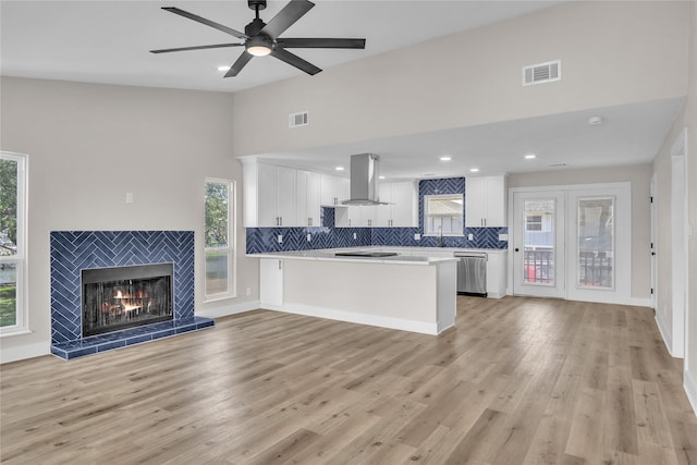 38 N Flamingo St, La Marque, TX 77568 - kitchen featuring stainless steel dishwasher, island range hood, light countertops, white cabinets, and tasteful backsplash