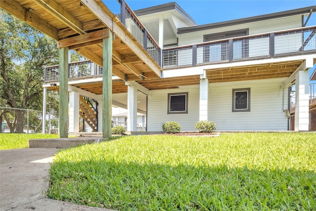 38 N Flamingo St, La Marque, TX 77568 - view of front facade with stairs, a front lawn, and a balcony