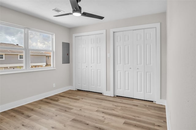 38 N Flamingo St, La Marque, TX 77568 - unfurnished bedroom with electric panel, two closets, light wood-type flooring, and a ceiling fan