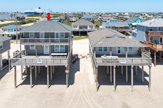 1314 Seashell Dr, Surfside Beach, TX 77541 - back of house with a balcony, a residential view, driveway, and a water view
