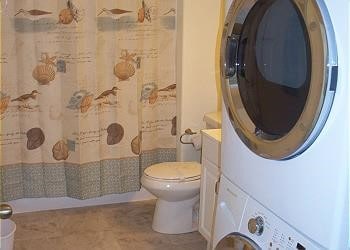1314 Seashell Dr, Surfside Beach, TX 77541 - full bathroom featuring stacked washer and clothes dryer, a shower with shower curtain, and vanity
