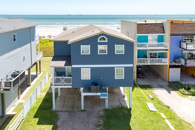 115 Southwind Dr, Surfside Beach, TX 77541 - rear view of house featuring a shingled roof, a water view, and a yard