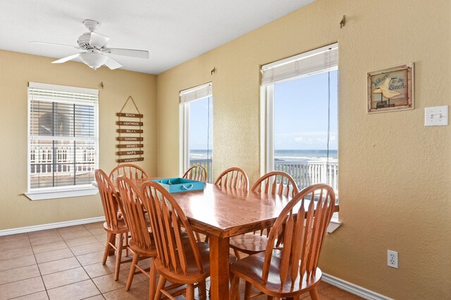 115 Southwind Dr, Surfside Beach, TX 77541 - dining space featuring light tile patterned floors, a ceiling fan, a water view, and a textured wall