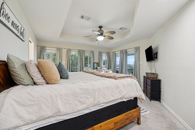 527 Caney Creek Dr, Livingston, TX 77351 - carpeted bedroom featuring access to outside, a raised ceiling, multiple windows, and ceiling fan