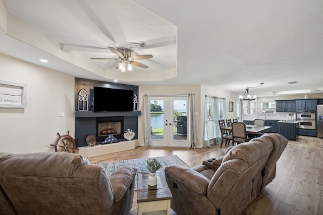 527 Caney Creek Dr, Livingston, TX 77351 - living area with ceiling fan, light wood-type flooring, a fireplace with raised hearth, french doors, and recessed lighting