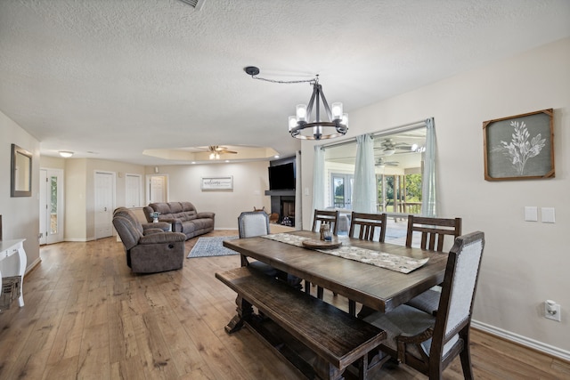 527 Caney Creek Dr, Livingston, TX 77351 - dining area featuring ceiling fan, a chandelier, light wood-type flooring, and a textured ceiling