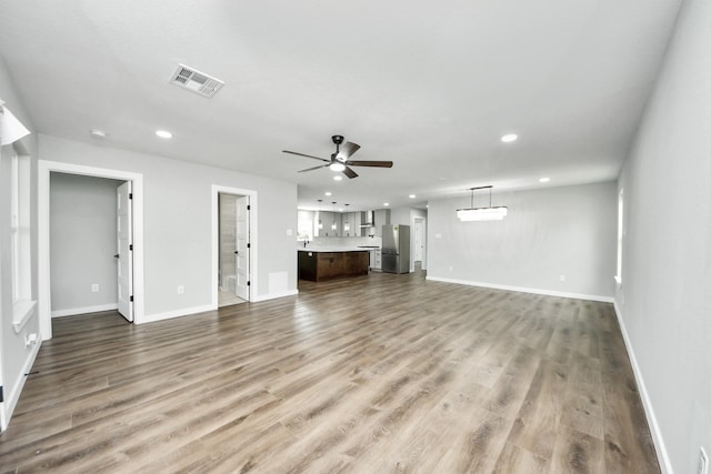 1218 Des Jardines St, Houston, TX 77023 - unfurnished living room featuring a ceiling fan, recessed lighting, and wood finished floors
