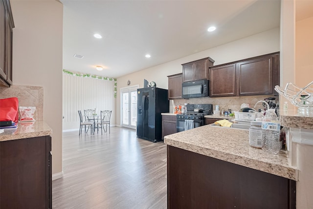 3638 Bright Moon Ct, Katy, TX 77449 - kitchen featuring black appliances, dark brown cabinetry, light countertops, backsplash, and light wood-style flooring