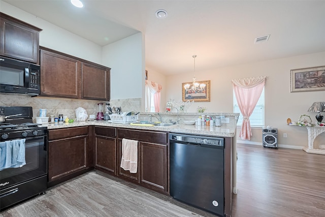 3638 Bright Moon Ct, Katy, TX 77449 - kitchen with black appliances, light wood-style floors, dark brown cabinetry, and a peninsula