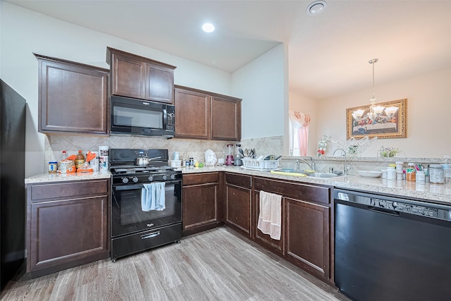 3638 Bright Moon Ct, Katy, TX 77449 - kitchen with black appliances, dark brown cabinetry, tasteful backsplash, and a chandelier