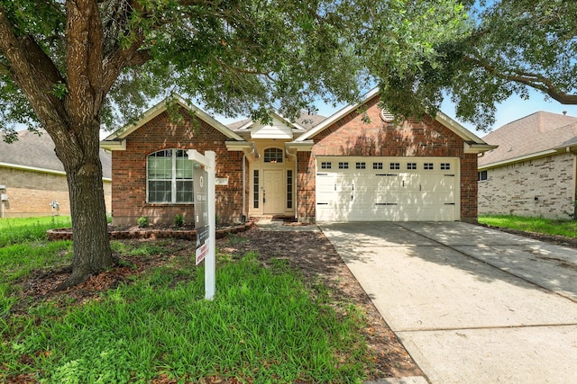 303 Burris Park Dr, Spring, TX 77373 - view of front of property featuring an attached garage, concrete driveway, and brick siding