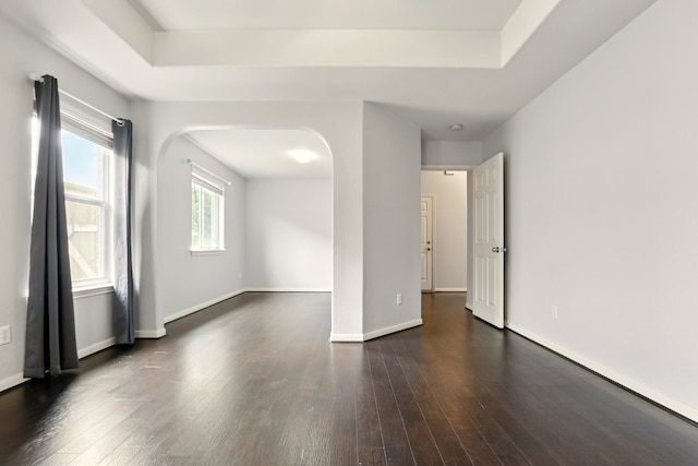 303 Burris Park Dr, Spring, TX 77373 - unfurnished room featuring dark wood-style floors, arched walkways, and a raised ceiling
