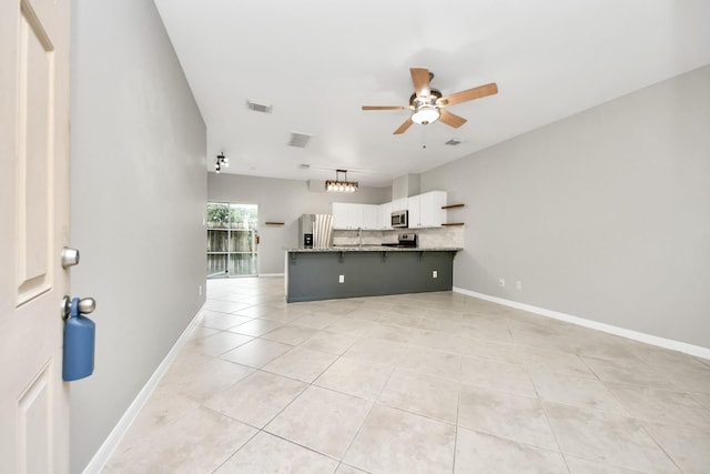 2214 Naomi St, Houston, TX 77054 - kitchen with appliances with stainless steel finishes, ceiling fan, white cabinets, light tile patterned floors, and tasteful backsplash