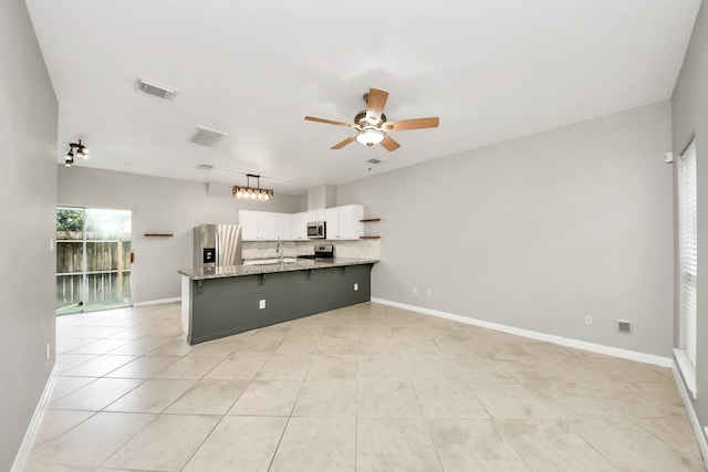 2214 Naomi St, Houston, TX 77054 - kitchen with appliances with stainless steel finishes, a peninsula, ceiling fan, white cabinets, and tasteful backsplash